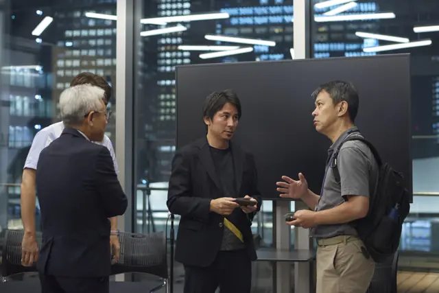 会場の外で名刺を交わし、立ち話をする参加者たち