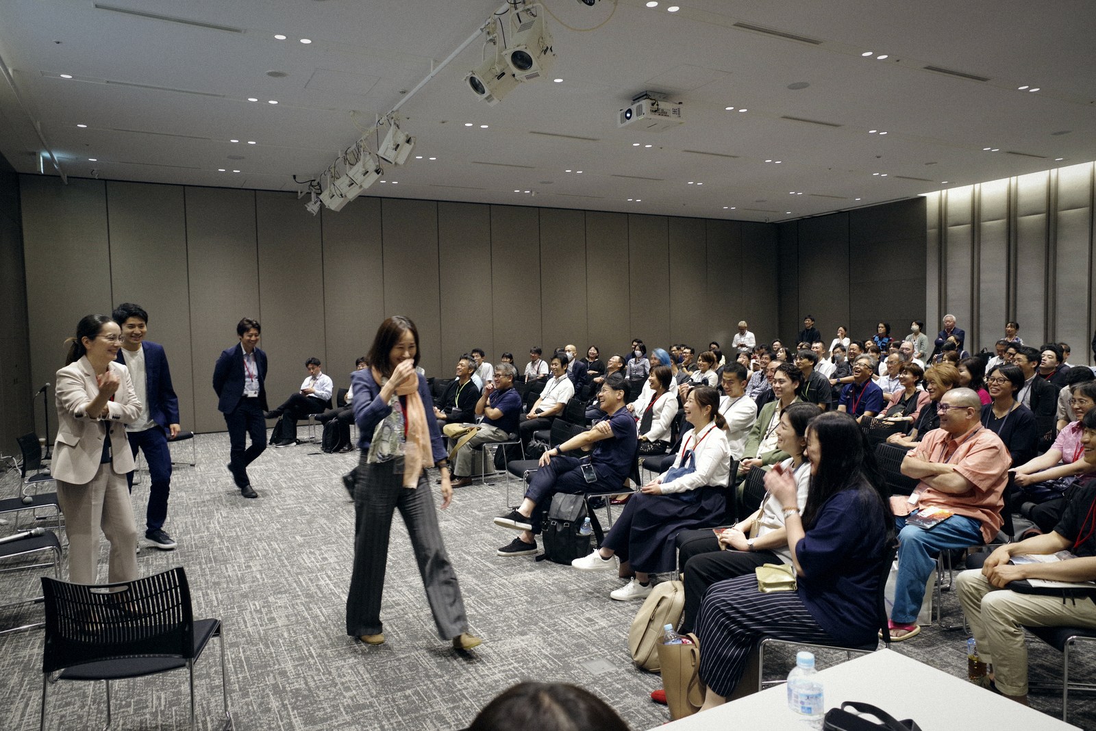 A participant standing to speak in a packed session room